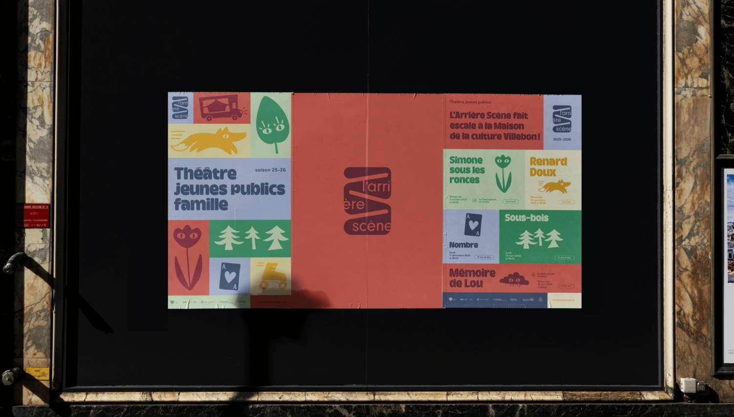Une grande affiche de théâtre dans un présentoir extérieur au cadre noir. Le design de l'affiche est une grille graphique moderne utilisant une palette de couleurs douces (rose, vert, bleu) et des icônes stylisées — renard, arbres, fleurs — pour illustrer la programmation.