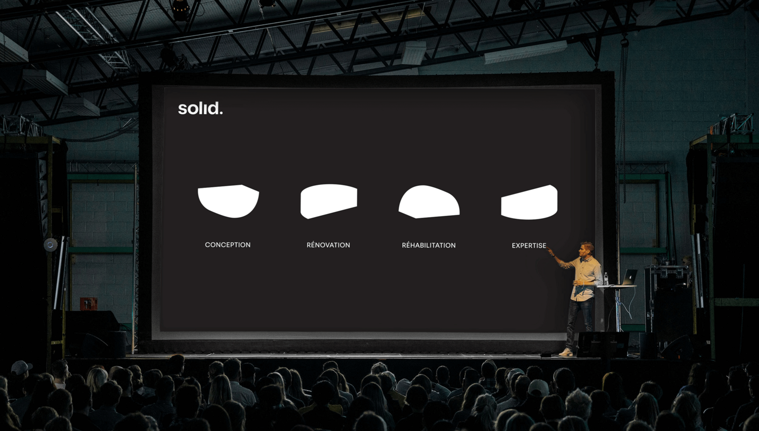 Présentation de Solid sur grand écran lors d'une conférence, avec des illustrations conceptuelles des services, soulignant la communication de marque.