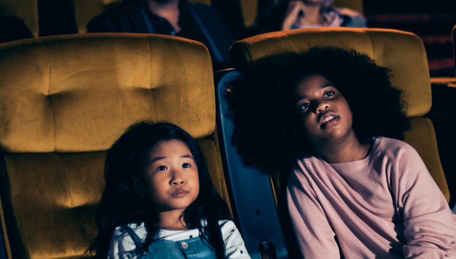 Deux enfants captivés dans un théâtre, représentant le public cible de la saison 2025-2026 de l'Arrière Scène.
