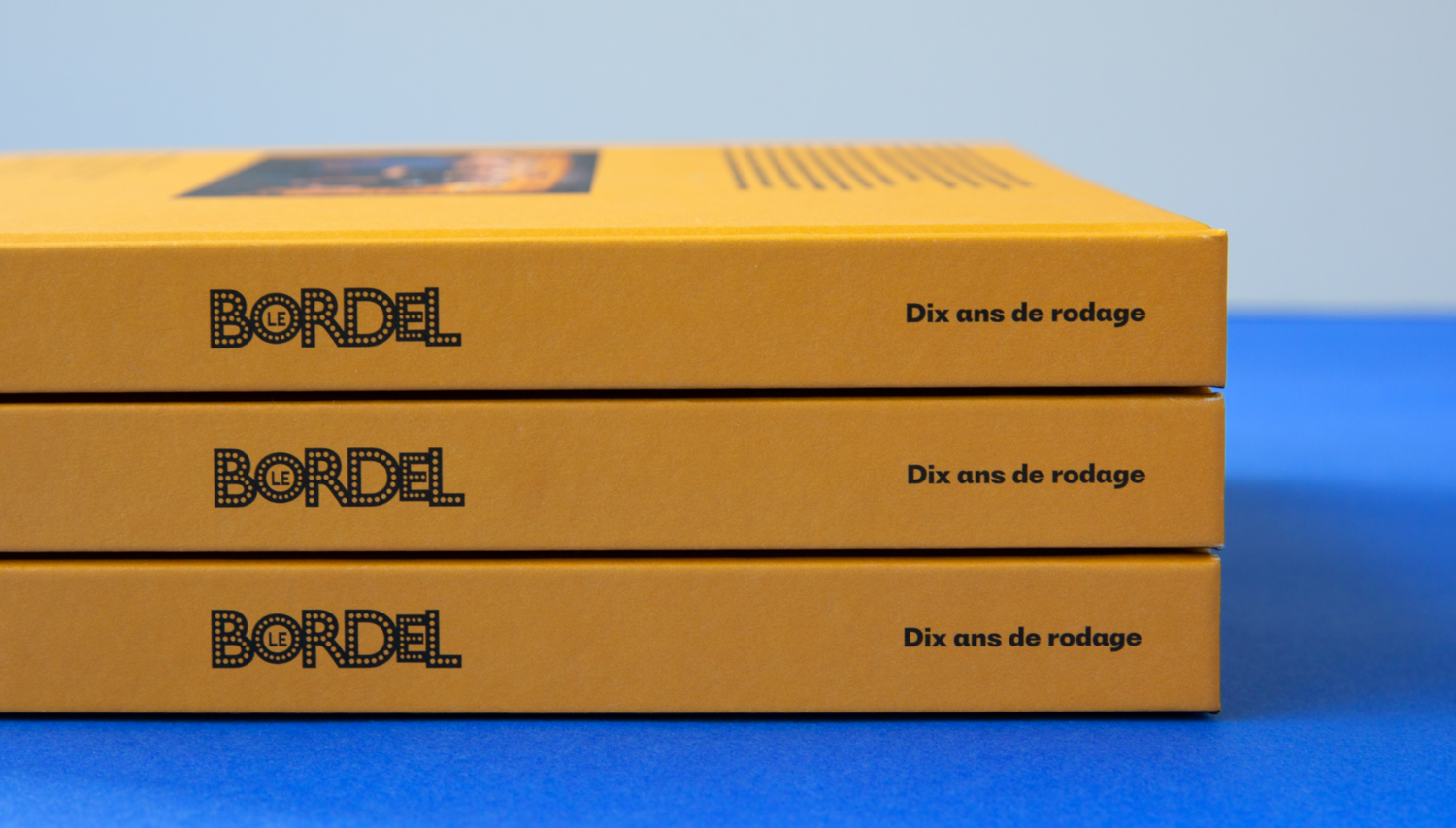 Photographie de la tranche du livre « Dix ans de rodage », mettant en valeur le design épuré, la typographie à points lumineuse et le jaune emblématique.