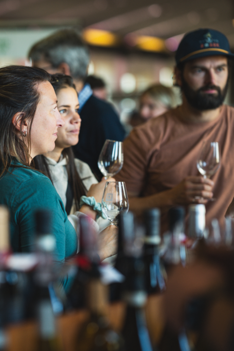 Groupe de personnes dégustant du vin dans une ambiance conviviale, illustrant l’expérience utilisateur et l’identité Raspipav centrée sur la passion du vin.
