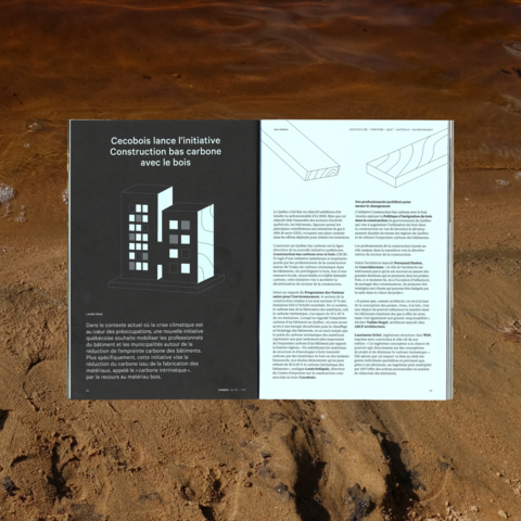Une page du magazine au design graphique en noir et blanc repose sur le sable au bord de l’eau. Cette présentation minimaliste met en exergue les réflexions conceptuelles sur l'avenir de la construction.