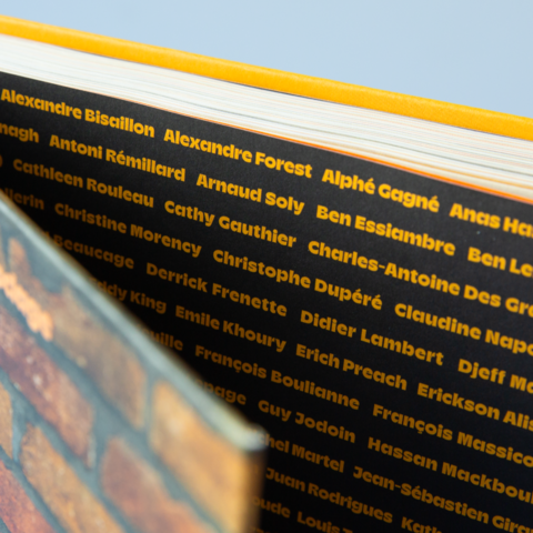 Gros plan sur la tranche des pages révélant une impressionnante liste de noms d'humoristes (Alexandre Forest, Arnaud Soly, Cathy Gauthier, etc.) imprimée en jaune sur fond noir