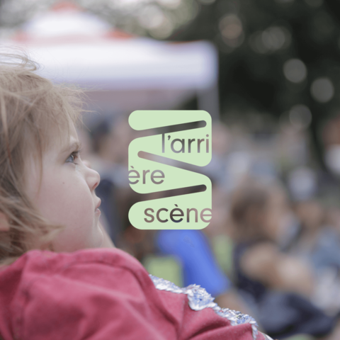 Jeune enfant au regard dirigé vers le théâtre avec le logo de l'arrière-scène en avant plan, soulignant l'impact visuel et l'engagement de la marque.
